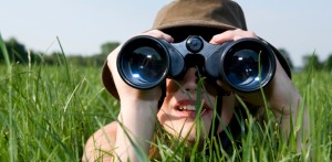 woman with binoculars in grass